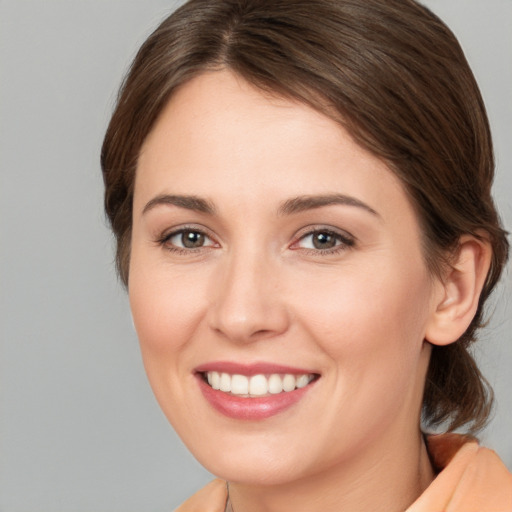 Joyful white young-adult female with medium  brown hair and brown eyes