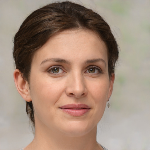 Joyful white young-adult female with medium  brown hair and green eyes