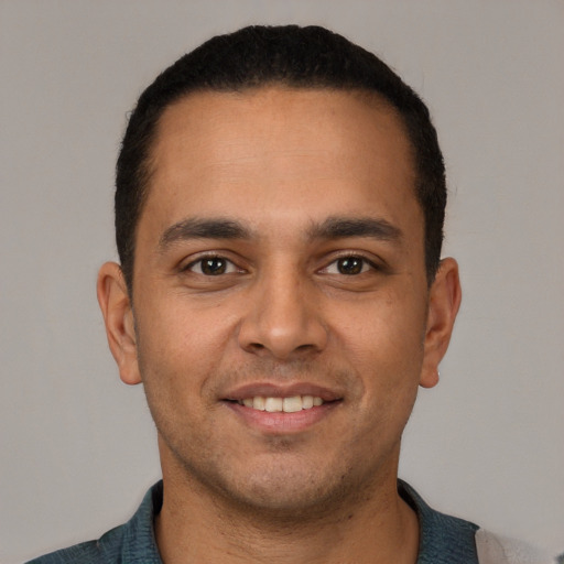 Joyful white young-adult male with short  black hair and brown eyes