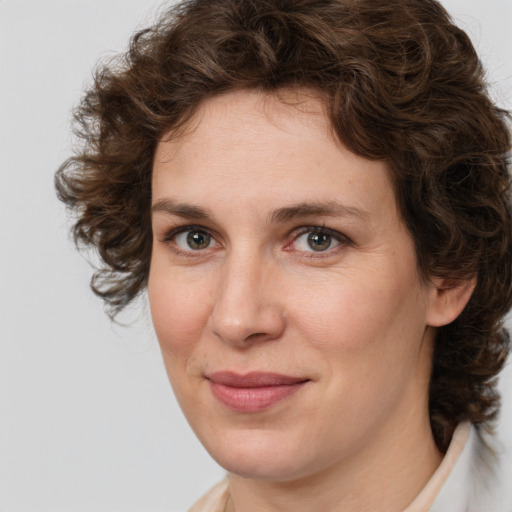 Joyful white young-adult female with medium  brown hair and green eyes