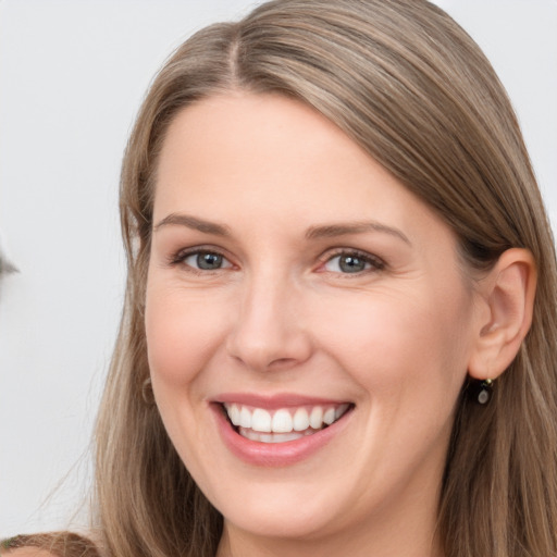 Joyful white young-adult female with long  brown hair and grey eyes