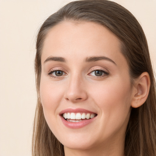 Joyful white young-adult female with long  brown hair and grey eyes