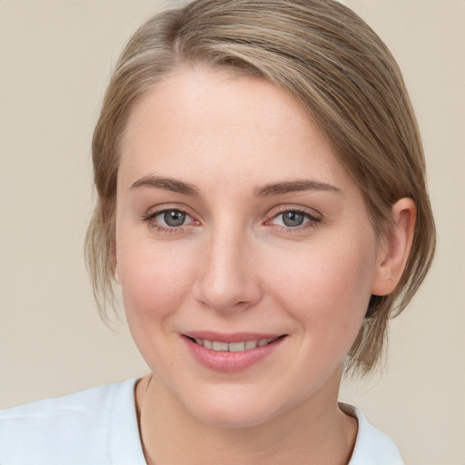 Joyful white young-adult female with medium  brown hair and blue eyes