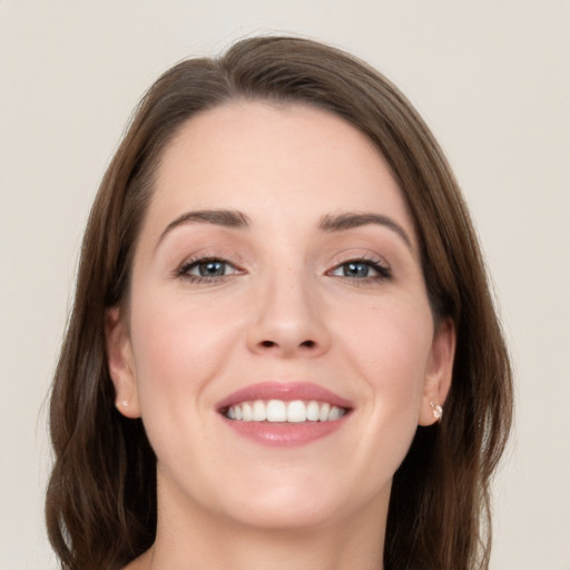 Joyful white young-adult female with long  brown hair and grey eyes