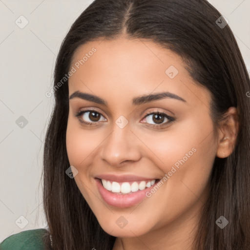 Joyful latino young-adult female with long  brown hair and brown eyes