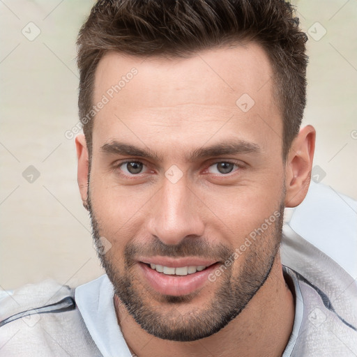 Joyful white young-adult male with short  brown hair and brown eyes