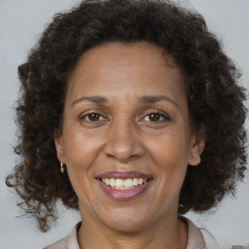 Joyful black adult female with medium  brown hair and brown eyes