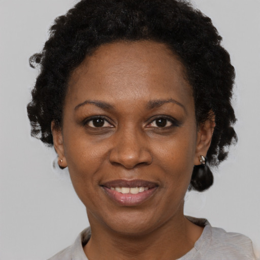 Joyful black adult female with short  black hair and brown eyes