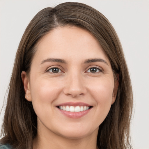 Joyful white young-adult female with long  brown hair and brown eyes