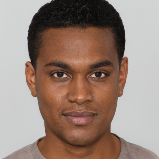 Joyful black young-adult male with short  brown hair and brown eyes