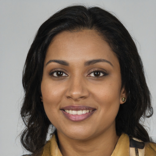 Joyful black young-adult female with long  brown hair and brown eyes