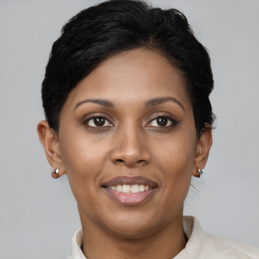 Joyful black young-adult female with short  black hair and brown eyes