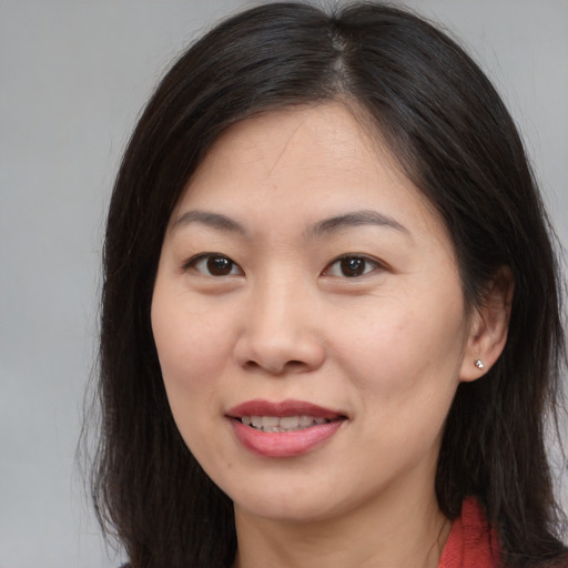 Joyful asian young-adult female with long  brown hair and brown eyes