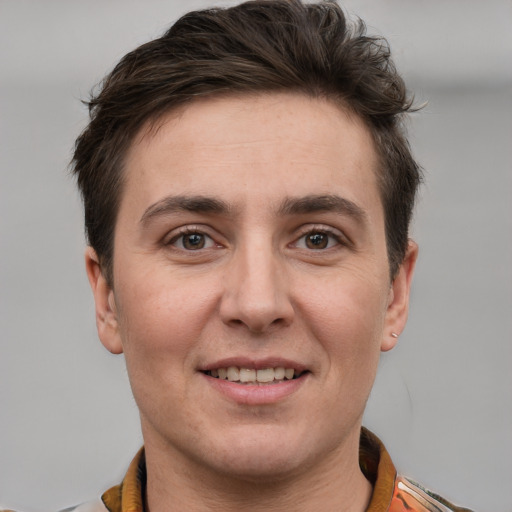 Joyful white young-adult male with short  brown hair and grey eyes