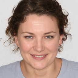 Joyful white young-adult female with medium  brown hair and blue eyes