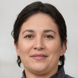 Joyful white adult female with medium  brown hair and brown eyes