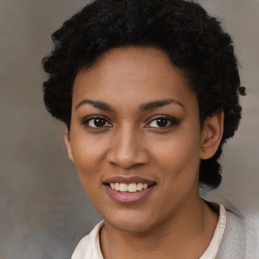 Joyful black young-adult female with short  black hair and brown eyes