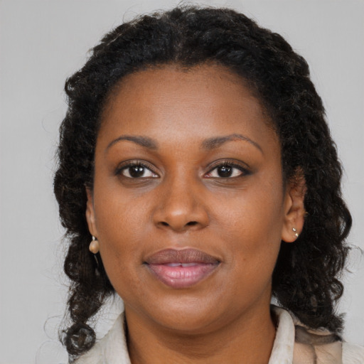 Joyful black young-adult female with long  brown hair and brown eyes