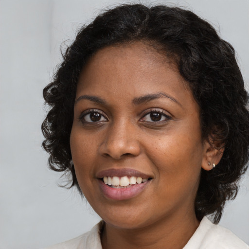 Joyful black young-adult female with medium  brown hair and brown eyes