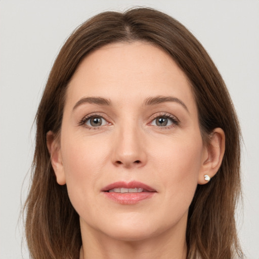 Joyful white adult female with long  brown hair and grey eyes