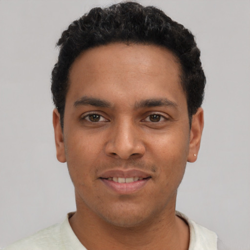 Joyful latino young-adult male with short  black hair and brown eyes
