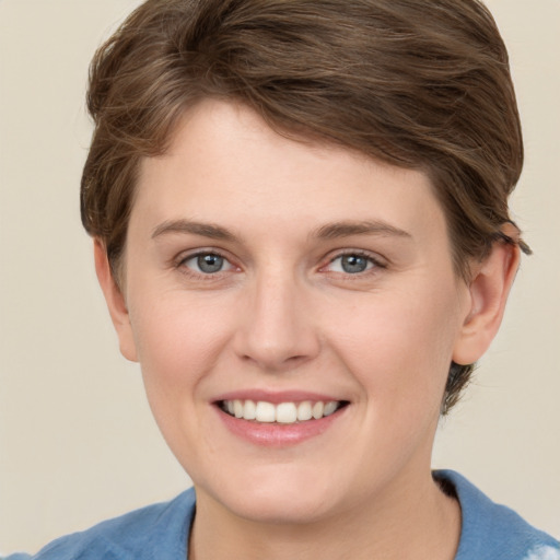 Joyful white young-adult female with short  brown hair and grey eyes