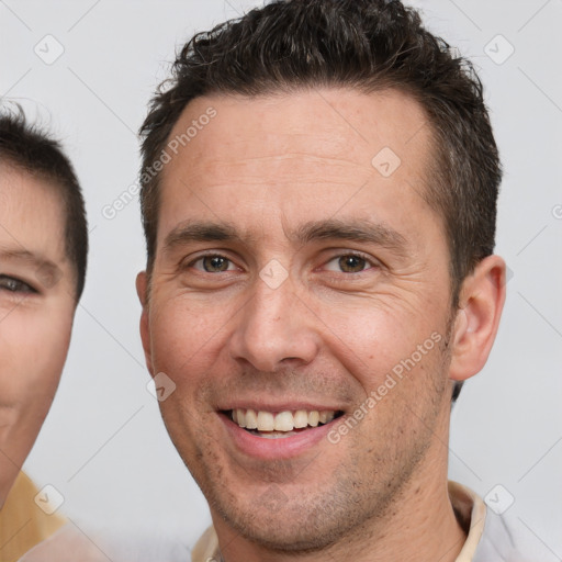 Joyful white adult male with short  brown hair and brown eyes