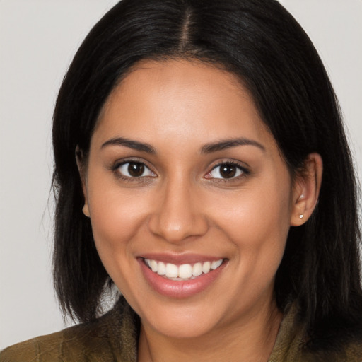 Joyful latino young-adult female with long  brown hair and brown eyes