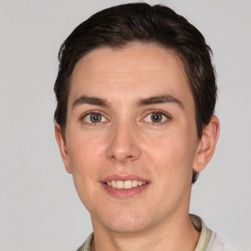 Joyful white young-adult male with short  brown hair and grey eyes