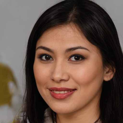 Joyful latino young-adult female with long  brown hair and brown eyes