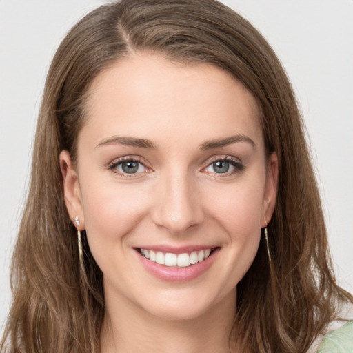 Joyful white young-adult female with long  brown hair and grey eyes