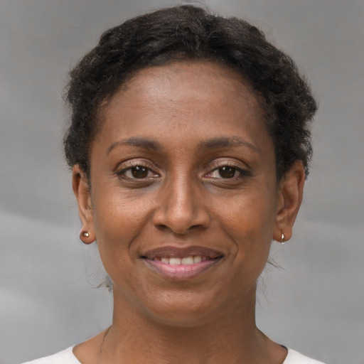 Joyful black young-adult female with short  brown hair and brown eyes