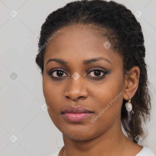 Joyful black young-adult female with long  black hair and brown eyes