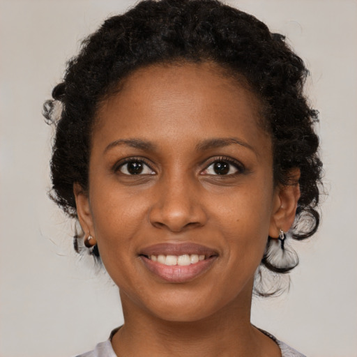 Joyful black young-adult female with medium  brown hair and brown eyes