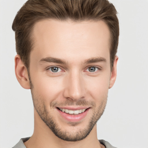 Joyful white young-adult male with short  brown hair and grey eyes