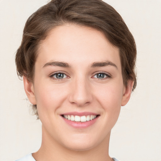 Joyful white young-adult female with short  brown hair and grey eyes