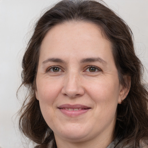 Joyful white adult female with long  brown hair and brown eyes