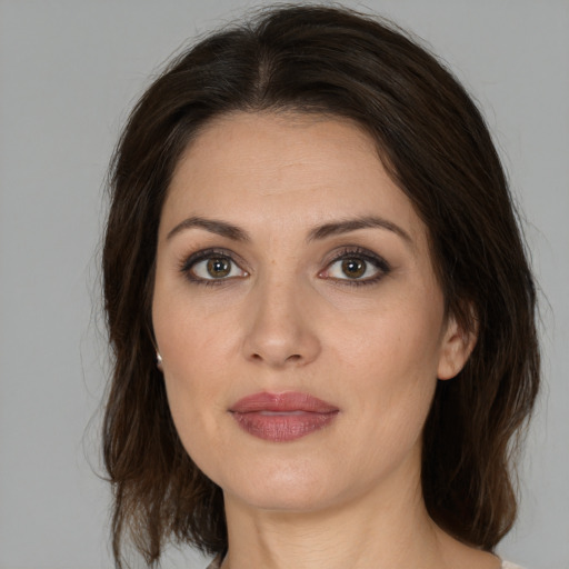 Joyful white adult female with medium  brown hair and brown eyes