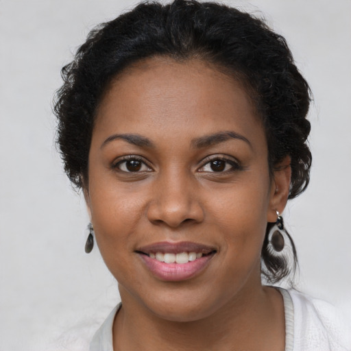 Joyful black young-adult female with short  brown hair and brown eyes