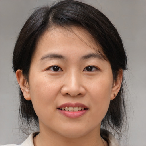 Joyful asian young-adult female with medium  brown hair and brown eyes