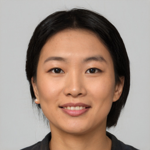 Joyful asian young-adult female with medium  black hair and brown eyes