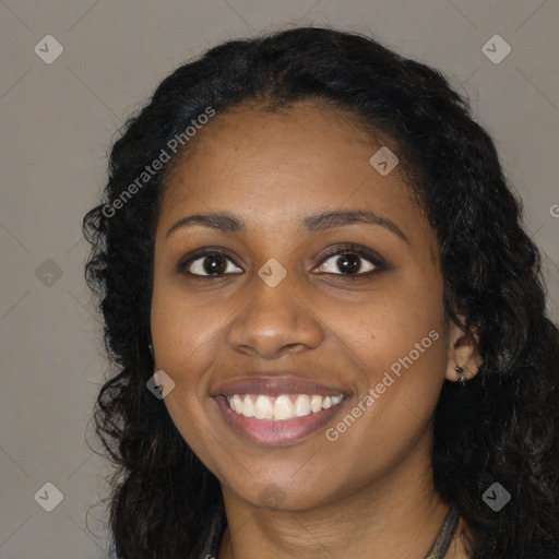 Joyful black young-adult female with long  black hair and brown eyes