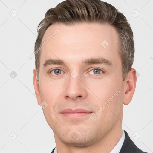 Joyful white young-adult male with short  brown hair and grey eyes