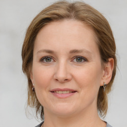 Joyful white young-adult female with medium  brown hair and grey eyes