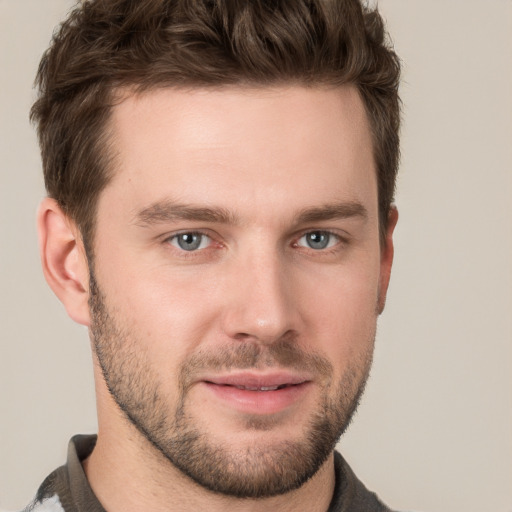 Joyful white young-adult male with short  brown hair and grey eyes