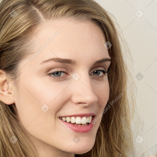 Joyful white young-adult female with long  brown hair and blue eyes