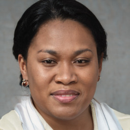 Joyful black adult female with medium  brown hair and brown eyes