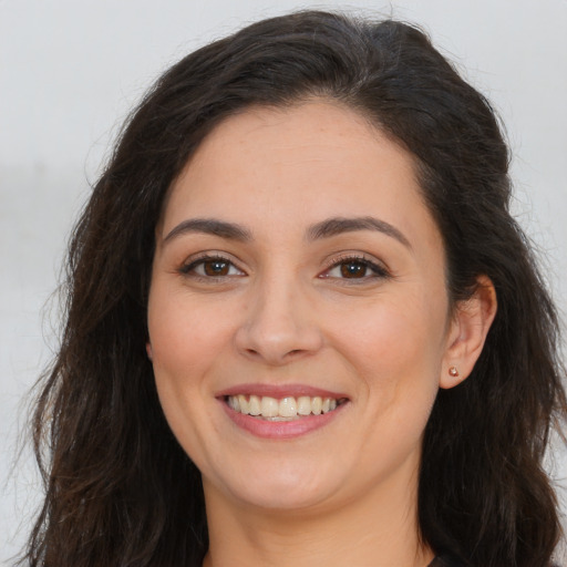 Joyful white young-adult female with long  brown hair and brown eyes