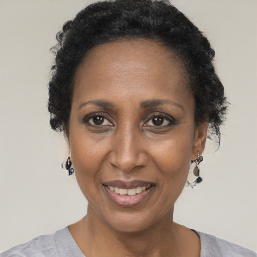 Joyful black adult female with short  black hair and brown eyes