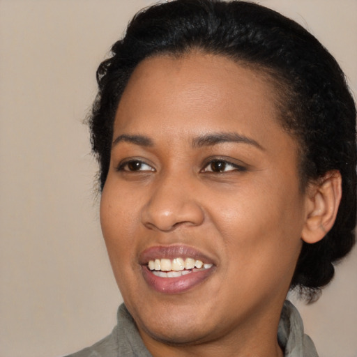 Joyful black young-adult female with medium  black hair and brown eyes